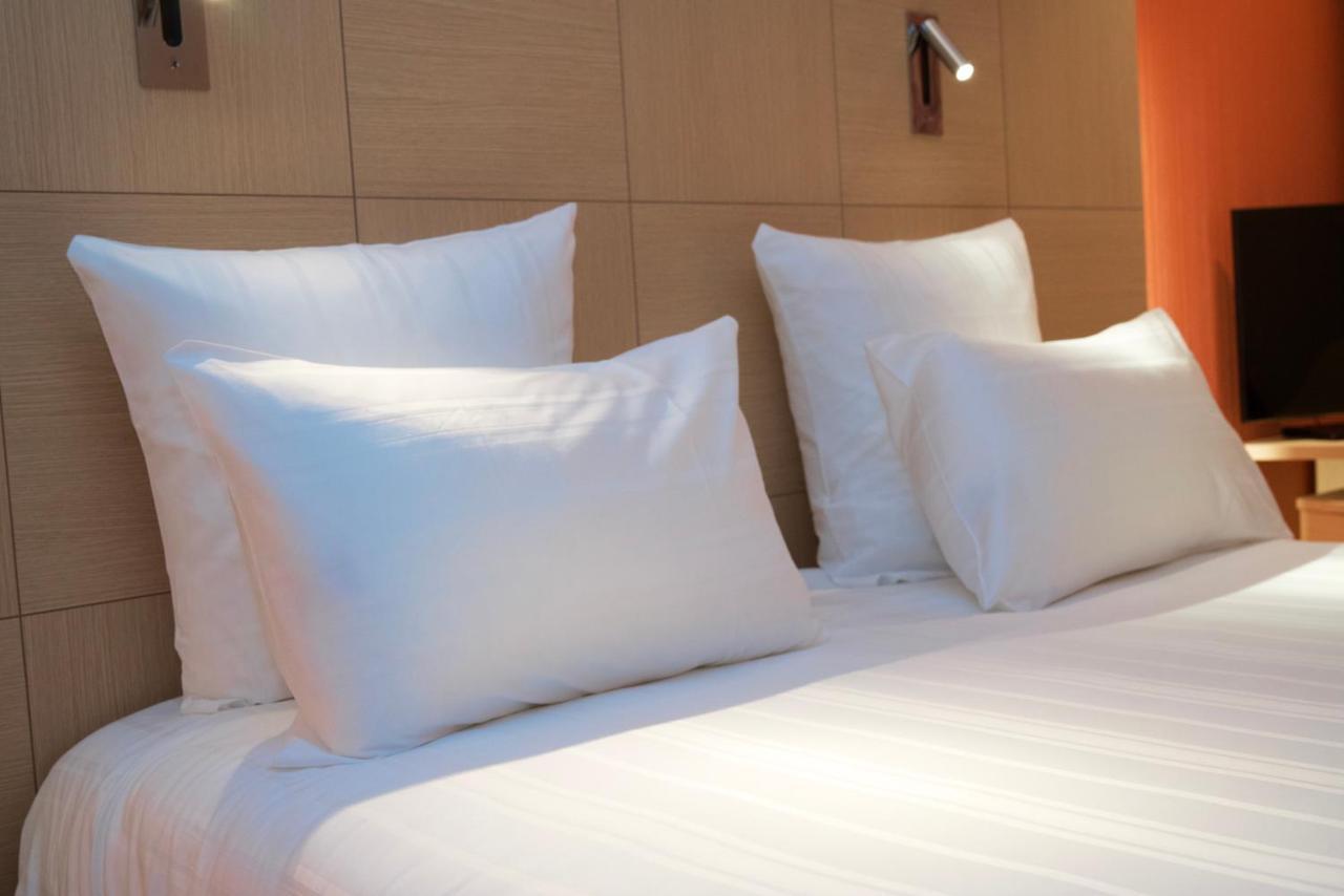 纳什机场酒店 Meyrin 外观 照片 "A bed and pillows in a hotel room"